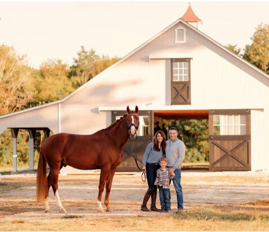 family with horse outside of barn