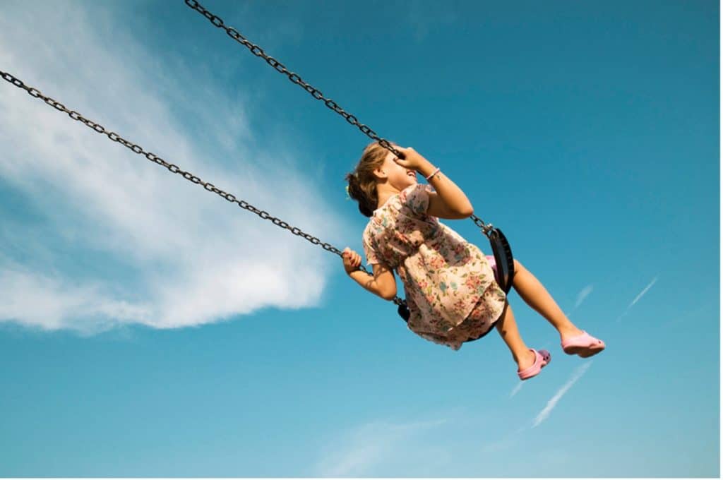 kid swinging on playset